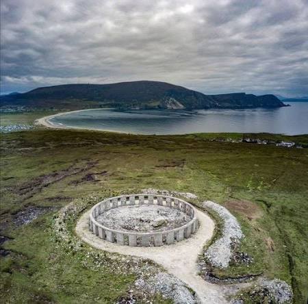 An aerial view of a stone circle on Achill Island, with Keel strand and the mountains beyond.